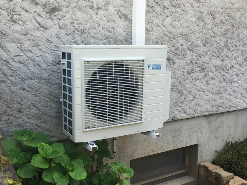 Groupe multisplit Daikin fixé sur un mur pignon avec descente des liaisons en goulotte